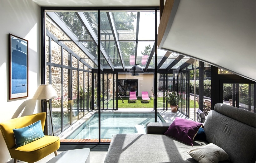 Piscine intérieure sous une véranda en extension d'habitation