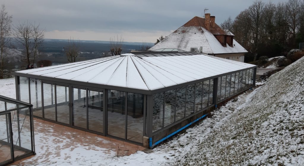 Couverture de piscine sous forme de véranda en hiver